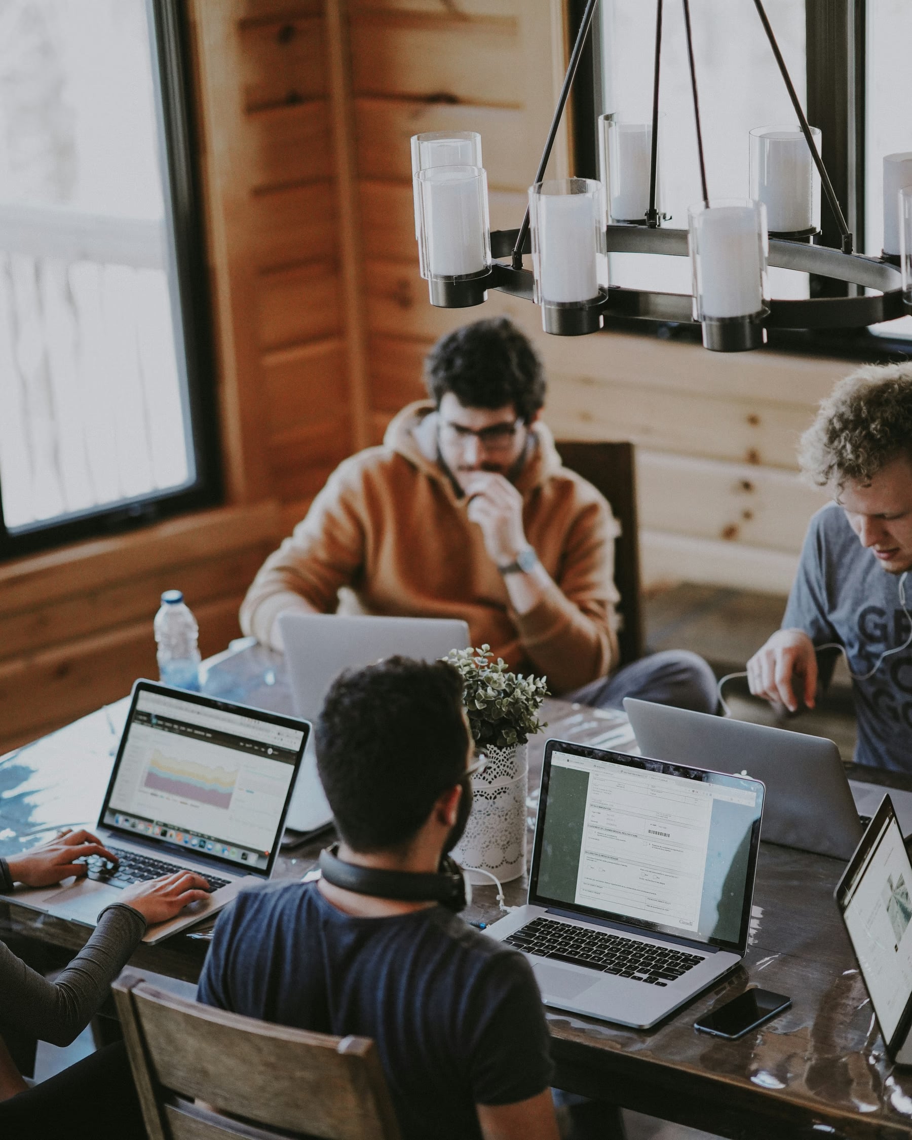 An agency team working around a wooden table with their laptops