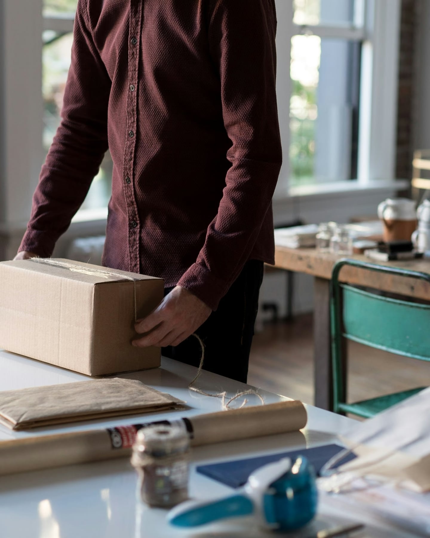 Someone tying up a parcel to ship an online order